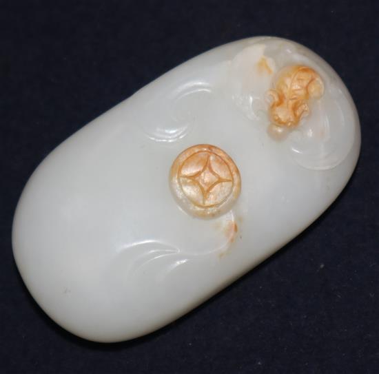 A Chinese white and russet jade pebble